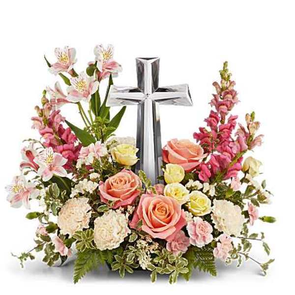 Pink and white floral arrangement with a silver cross centerpiece