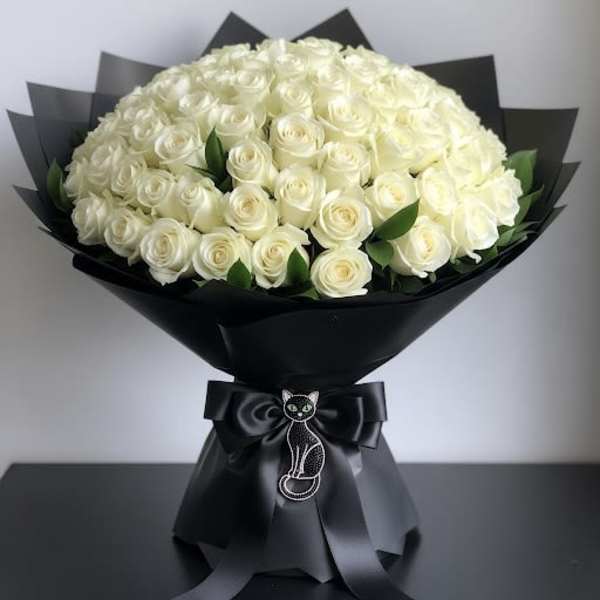 Bouquet of white roses wrapped in black paper with a cat ribbon charm