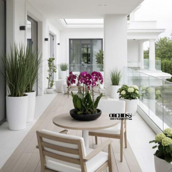 Orchid arrangement in a black bowl on a patio table