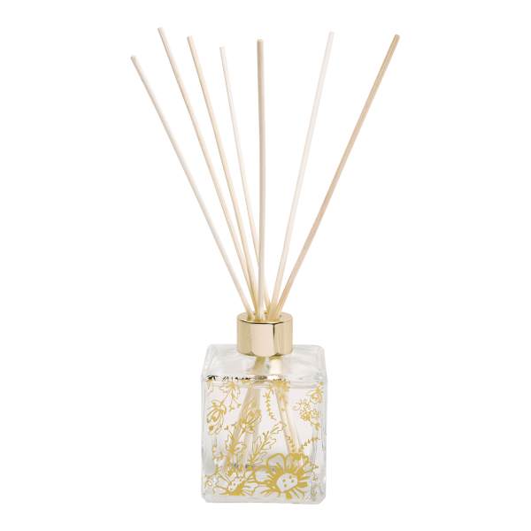 Decorative reed diffuser in a clear floral glass bottle