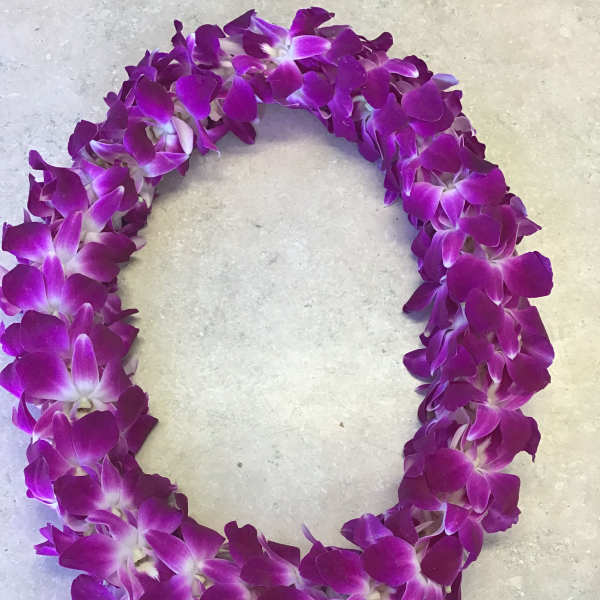 Purple orchid lei arranged in a circular garland