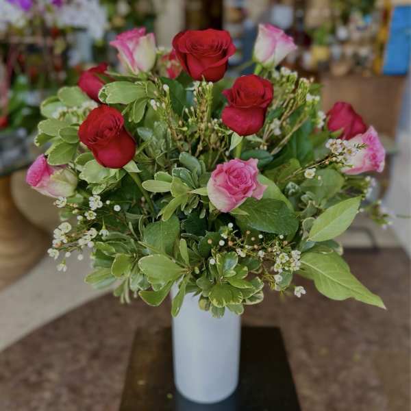 Bouquet of red and pink roses in a white vase