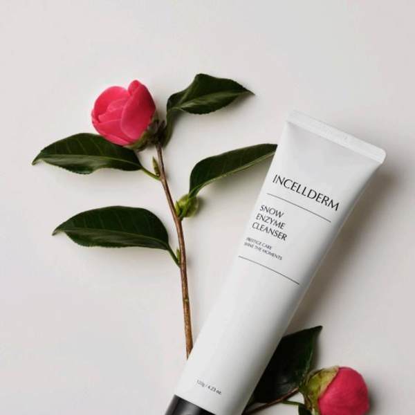 Pink flower sprigs beside a white cleanser tube