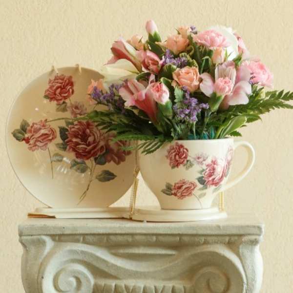 Pink floral bouquet in a floral teacup with matching saucer