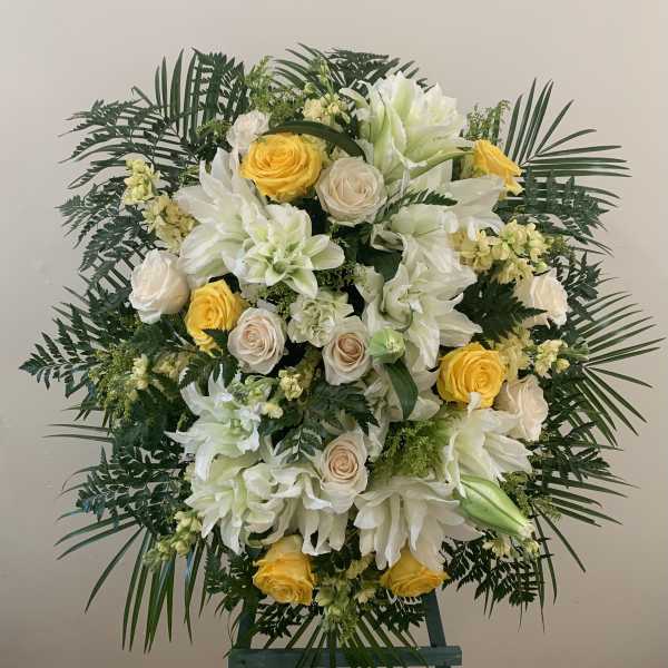 Large white and yellow floral standing spray on an easel