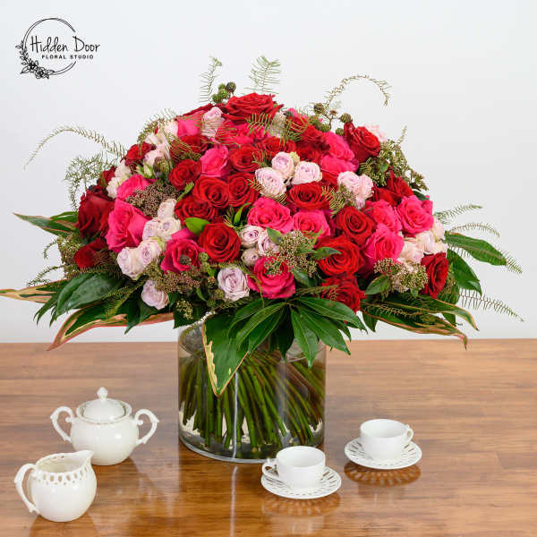 Large bouquet of red and pink roses in a glass vase