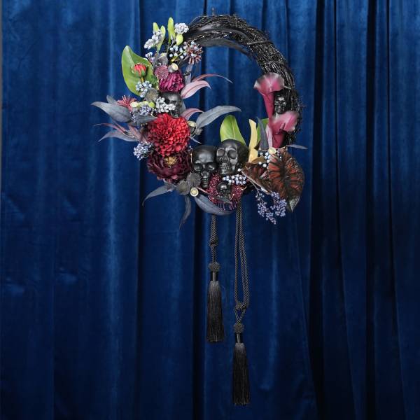 Decorative floral wreath with skull accents and hanging tassels
