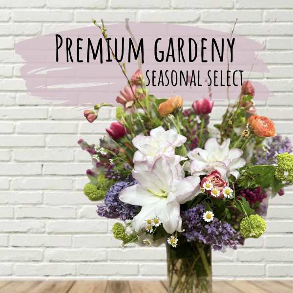 Mixed bouquet of white, pink, purple, and orange flowers in a glass vase