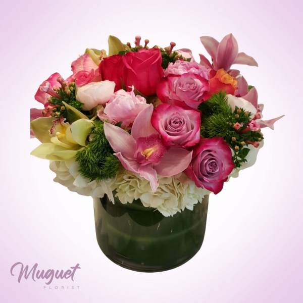 Pink and white mixed flower bouquet in a dark glass vase