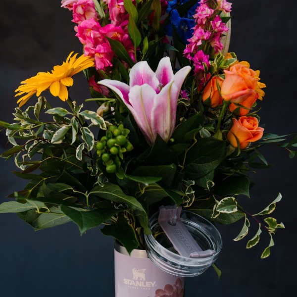 Mixed bouquet in a pink Stanley tumbler with a clear lid