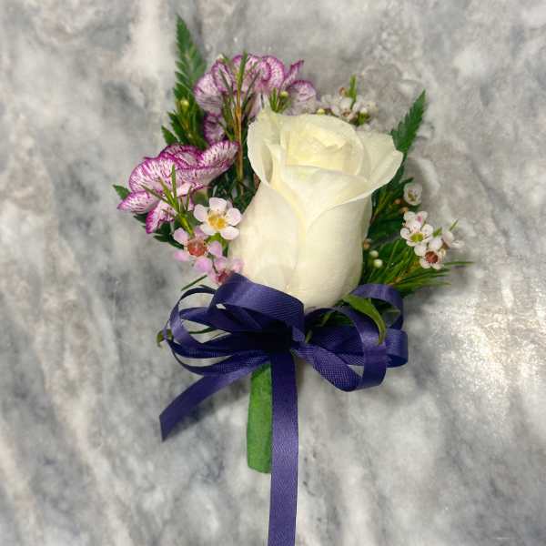White rose boutonniere with purple flowers and a blue ribbon