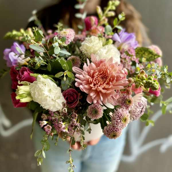 Handheld bouquet of pink, white, and purple flowers