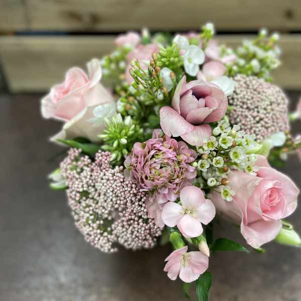 Pink roses and mixed blooms arranged in a compact bouquet
