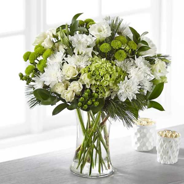 White and green floral arrangement in a clear glass vase