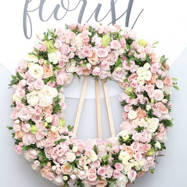 Large pastel floral wreath on a wooden easel