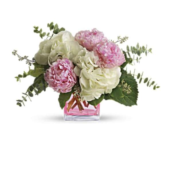 Pink and white peonies in a small pink glass vase