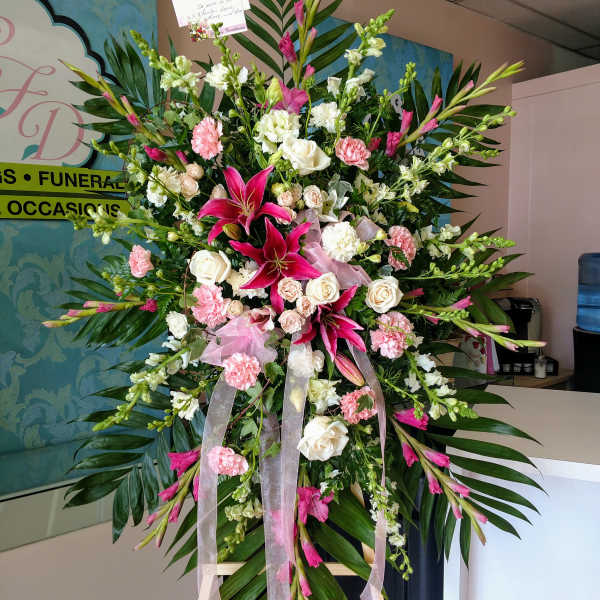 Large standing floral spray with pink and white flowers on an easel