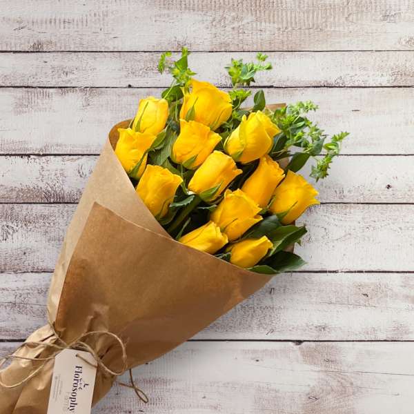 Bouquet of yellow roses wrapped in brown paper