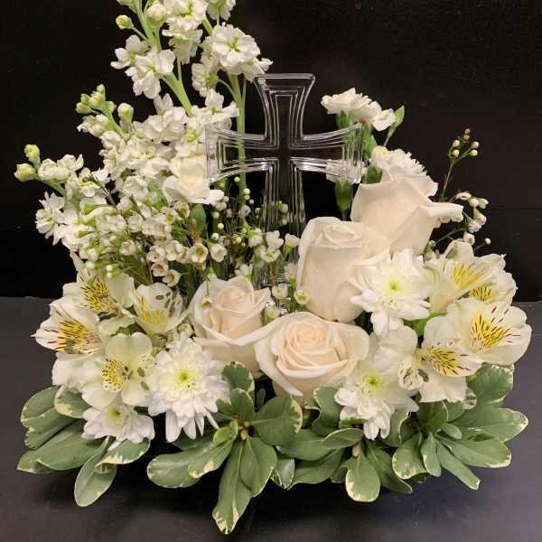 White floral arrangement with a clear cross centerpiece