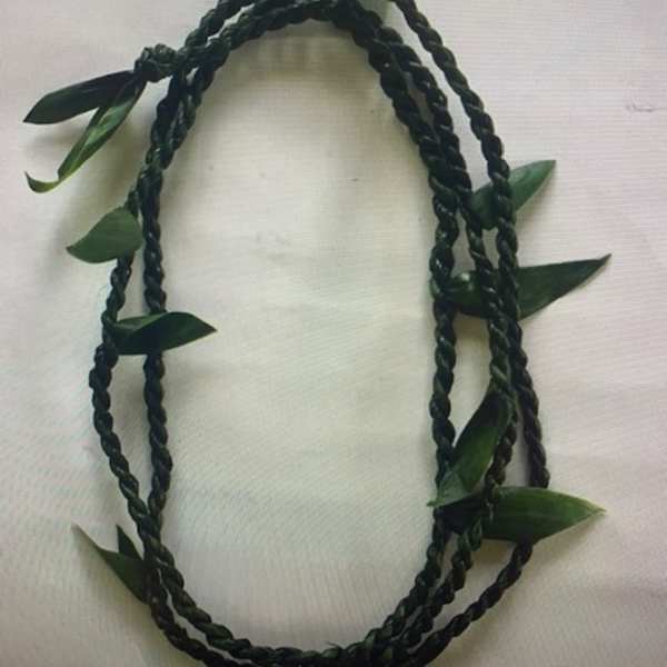 Braided dark green floral lei with scattered leaves