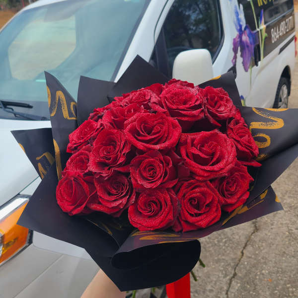Bouquet of red roses wrapped in black paper