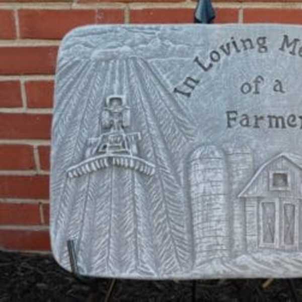 Memorial plaque with a farm scene and the words 'In Loving Memory of a Farmer'