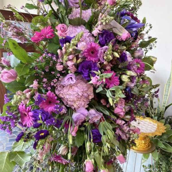 Large standing floral spray in pink, purple, and lavender tones