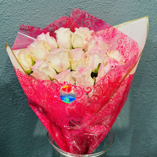 Bouquet of pale pink roses wrapped in bright pink paper