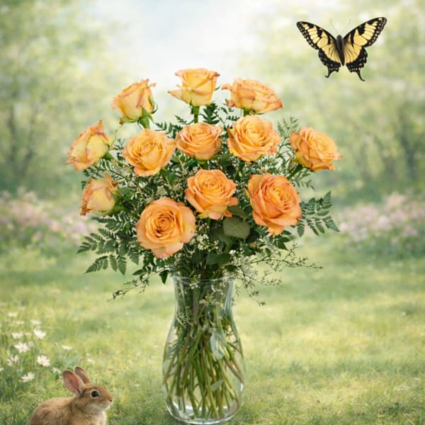 Orange roses in a clear glass vase with a butterfly and rabbit nearby