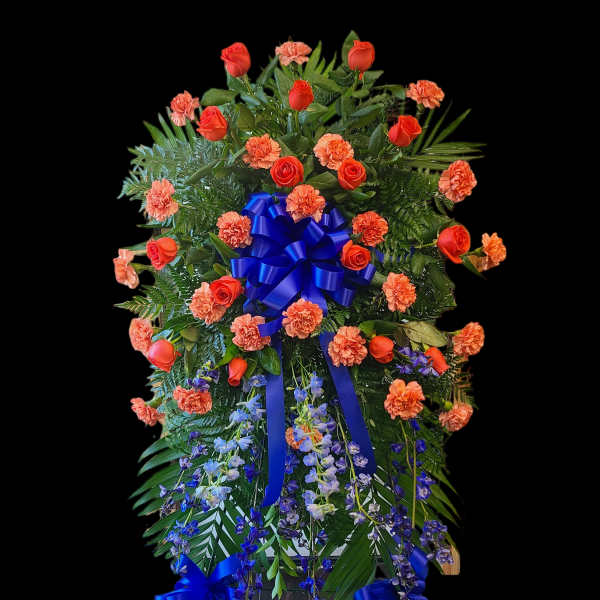 Standing floral spray with orange roses, carnations, and blue ribbon