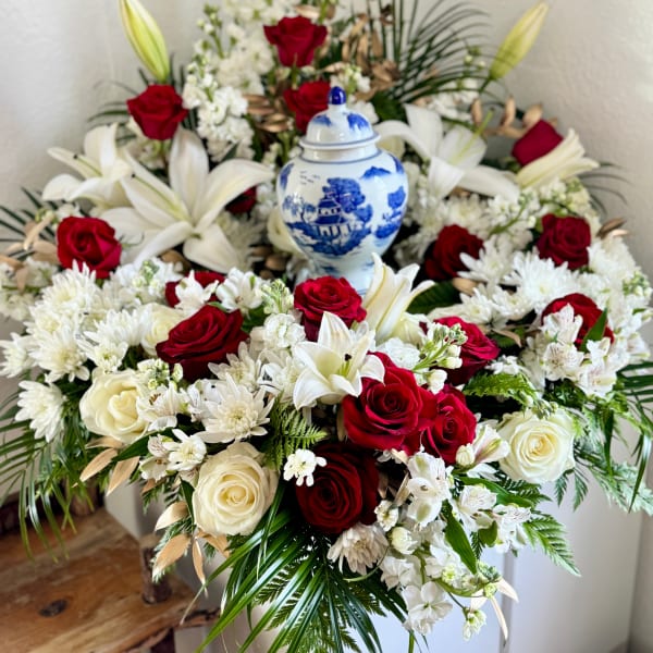 Red and white floral arrangement with a blue-and-white urn
