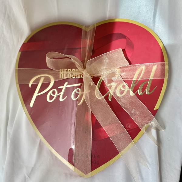 Heart-shaped box of Pot of Gold chocolates tied with a ribbon