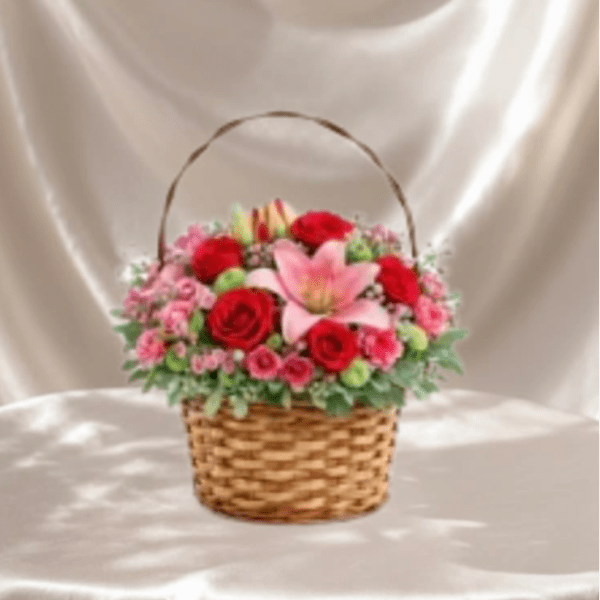 Basket arrangement of red and pink flowers with a pink lily