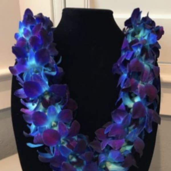Purple and blue orchid lei on a black display bust