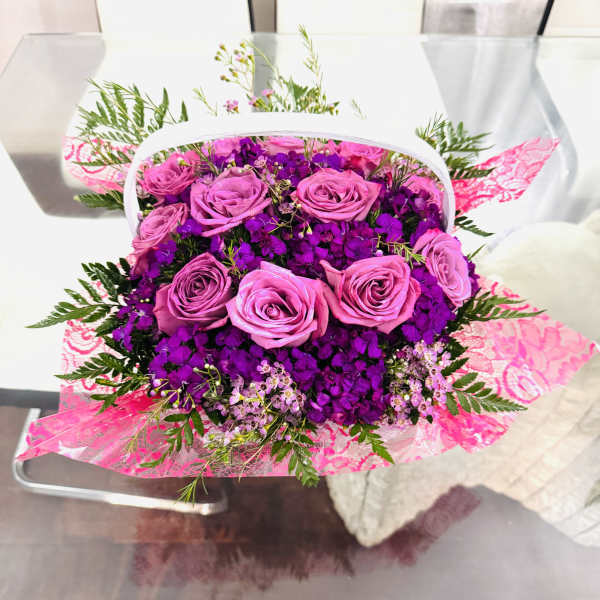 Pink roses and purple flowers in a wrapped bouquet