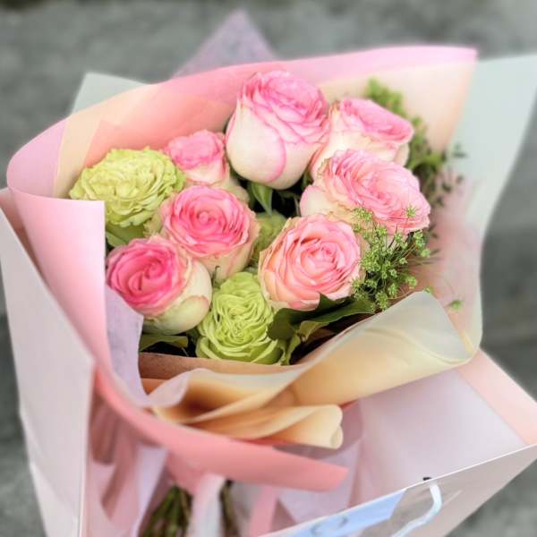 Pink and green rose bouquet wrapped in pastel paper