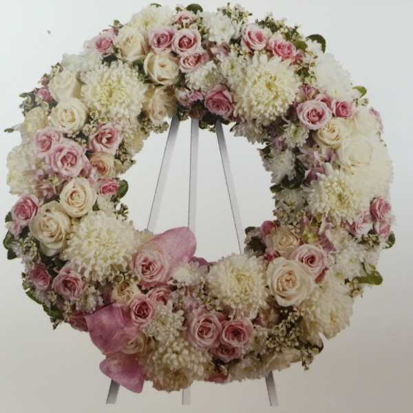 Pink and white floral wreath on a stand