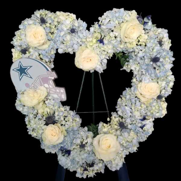 Heart-shaped floral wreath with pale blue and white flowers and cream roses