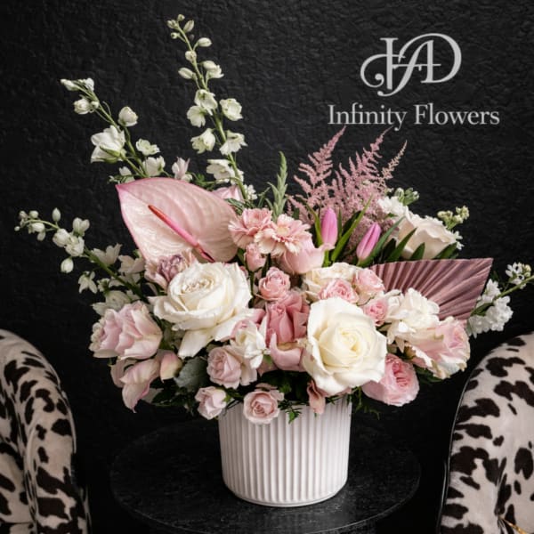 Pink and white floral arrangement in a ribbed white vase