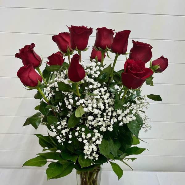 Red roses with white baby's breath in a clear glass vase