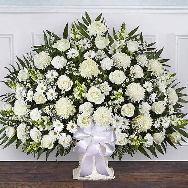 Large white floral standing spray with roses and daisies on a white easel