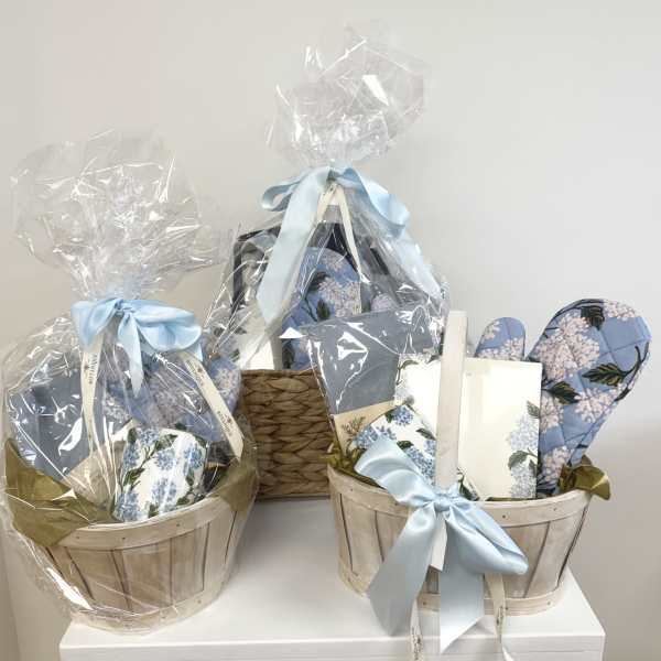 Gift baskets with blue floral items wrapped in clear cellophane and ribbon