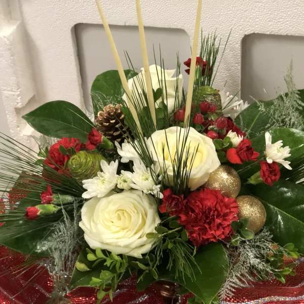 Holiday floral arrangement with white roses, red carnations, and gold ornaments
