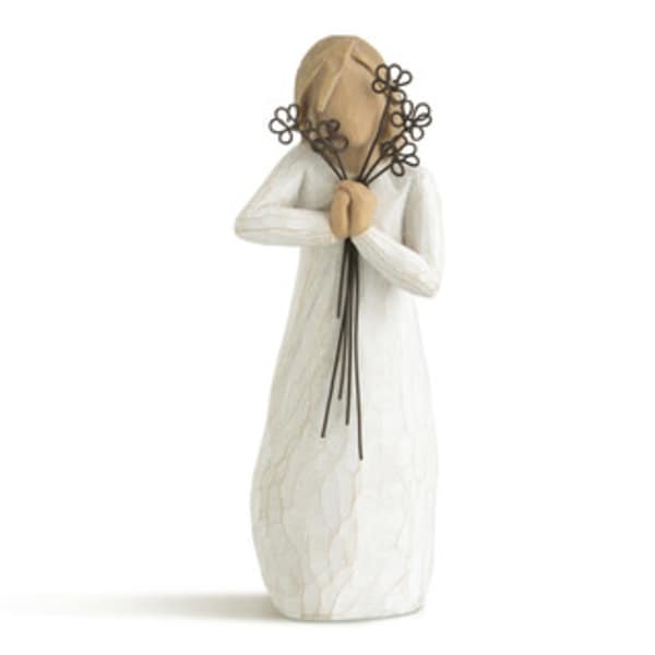 Decorative figurine in a white robe holding a small floral bouquet