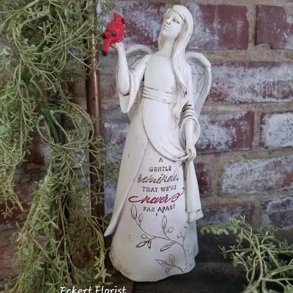 Angel figurine holding a red bird beside trailing greenery