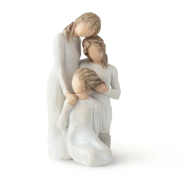 Three faceless figurines in white dresses posed closely together