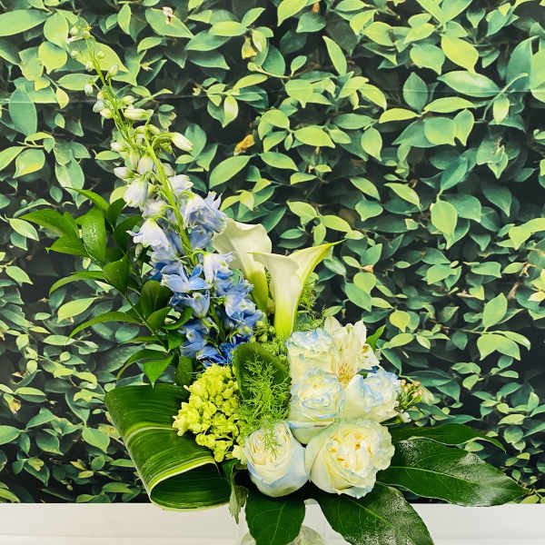 Blue and white flowers arranged in a clear glass vase