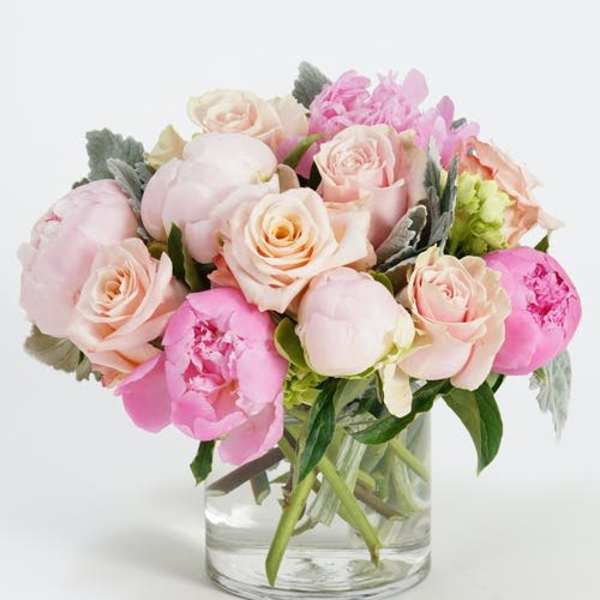 Pink and blush bouquet of roses and peonies in a clear glass vase