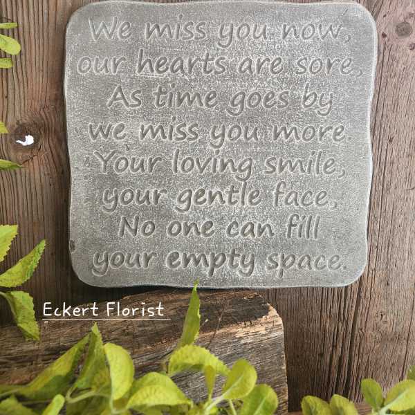 A memorial stone plaque with an engraved sympathy message.