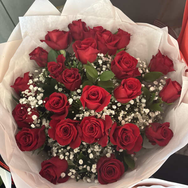 Bouquet of red roses with white baby's breath in white wrapping